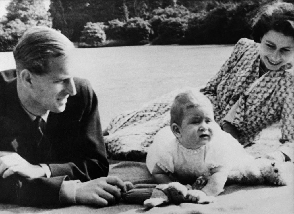 Princess Elizabeth and her husband Prince Philip, Duke of Edinburgh pose for a photo with a baby Prince Charles.