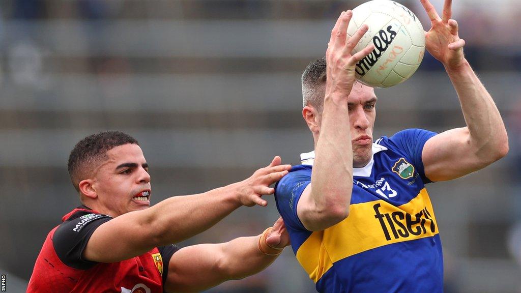 Down's Finn McElroy puts pressure on Mark Russell in Sunday's game at Semple Stadium