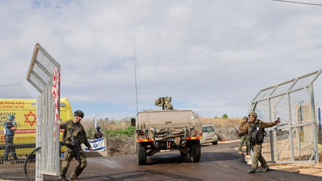 Israeli ambulance and soldiers at the entrance of Kfar Yuval in northern Israel after a Hezbollah anti-tank missile killed a woman and her son