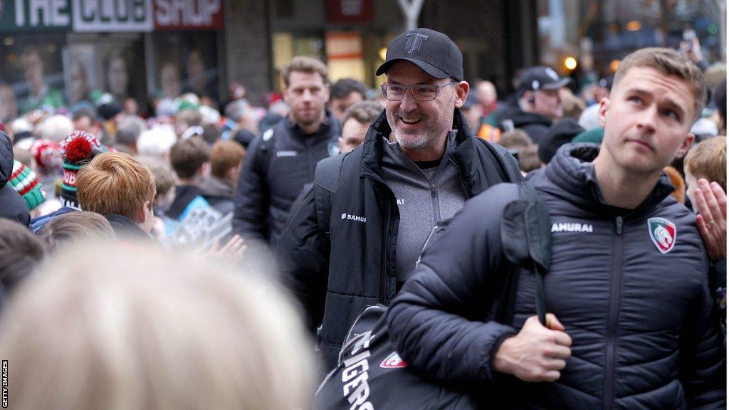 Leicester Tigers head coach Dan McKellar walks through crowd of fans an into the stadium with his players