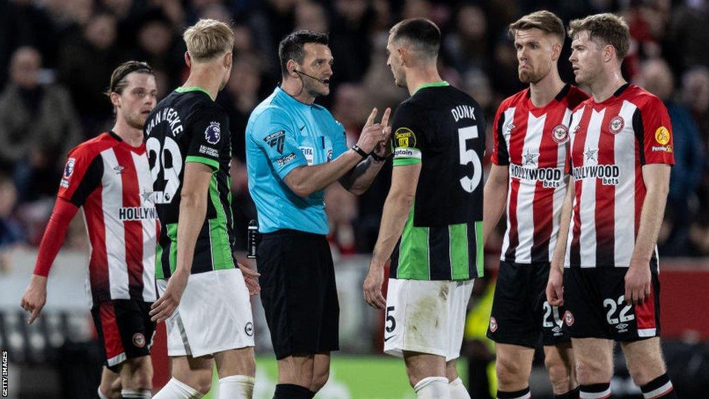 Andy Madley speaking to Lewis Dunk