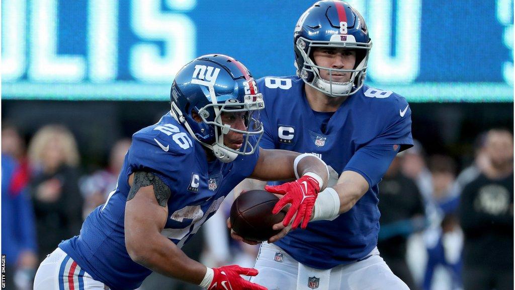 Daniel Jones hands the ball off to Saquon Barkley