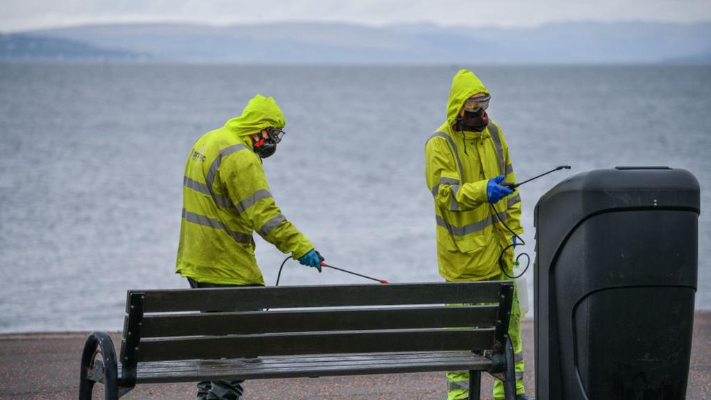 council staff cleaning bench and bin