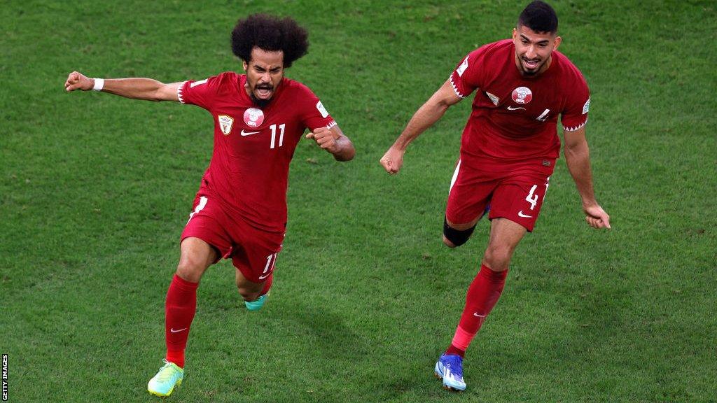 Akram Afif celebrates scoring his team's second goal with Mohammed Waad (right)