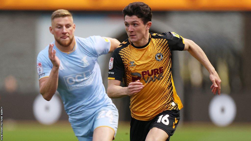 Calum Kavanagh of Newport County is challenged by Alfie Kilgour of Mansfield