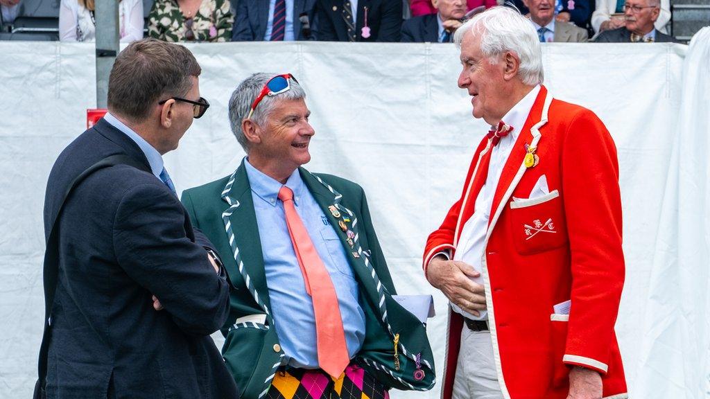 Three men in colourful outfits