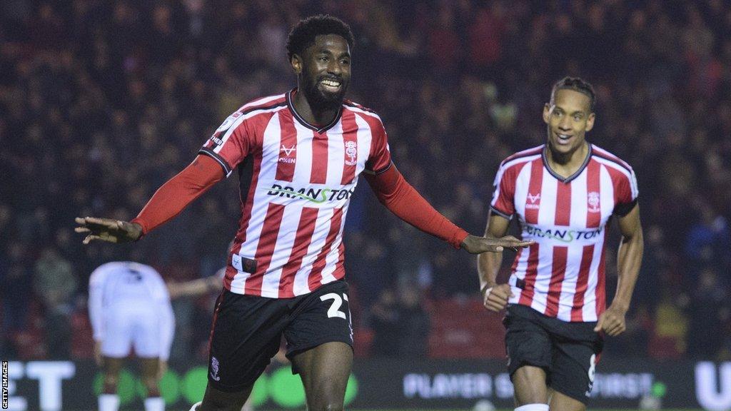 Hakeeb Adelakun celebrates scoring for Lincoln City