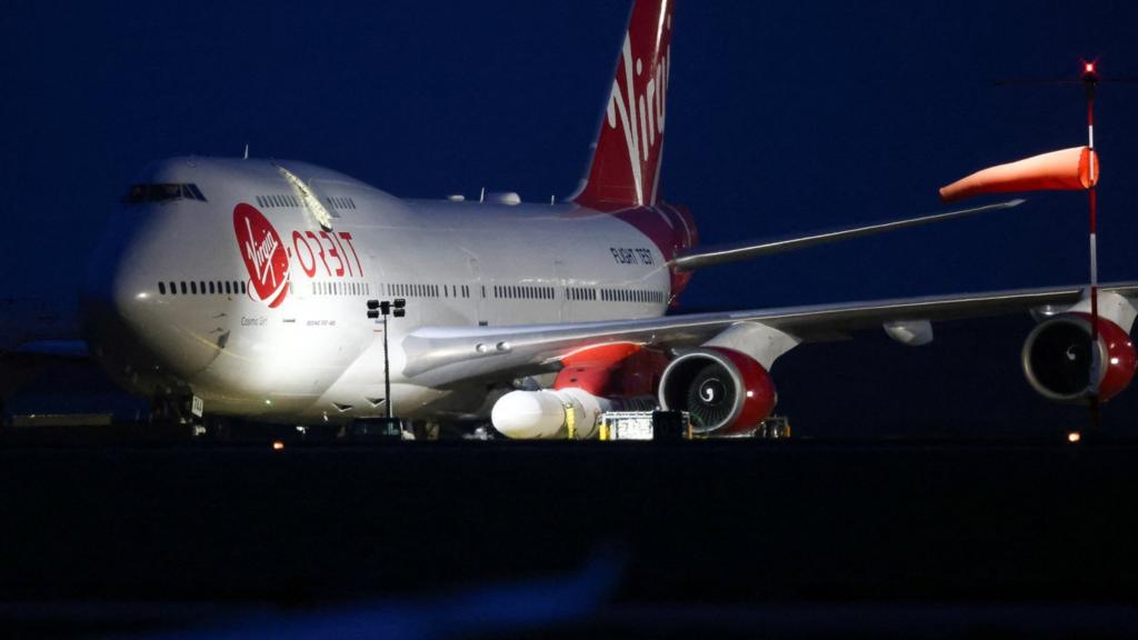 A Virgin Boeing 747-400 aircraft sits on the tarmac with Virgin Orbit's LauncherOne rocket attached to the wing at Spaceport Cornwall at Newquay Airport in Newquay