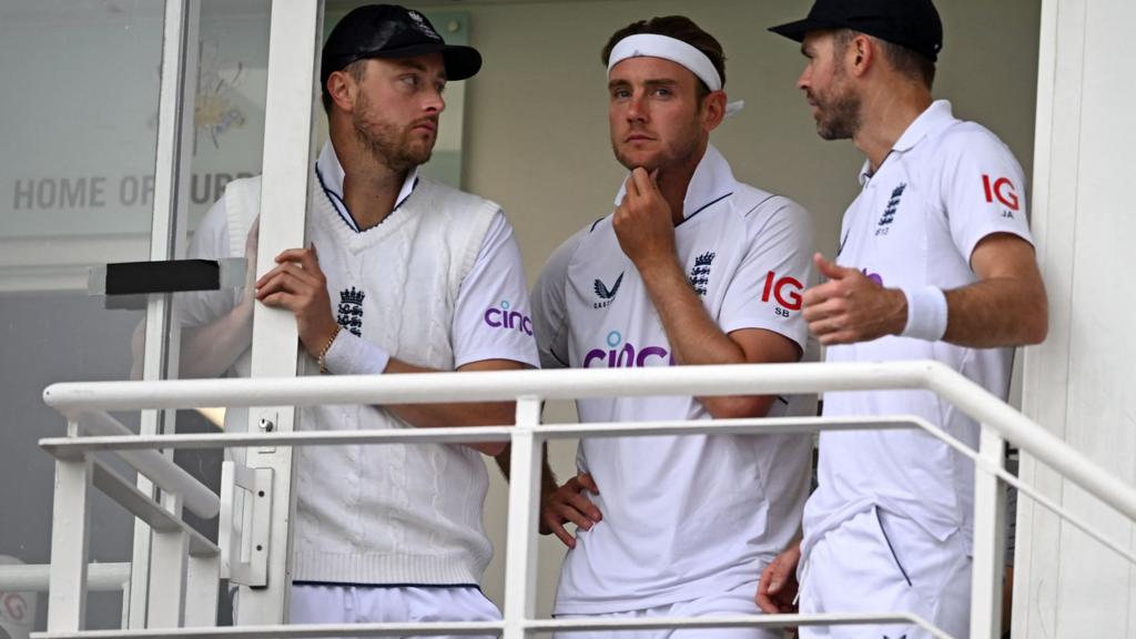 England bowlers Ollie Robinson (left), Stuart Board (centre) and James Anderson (right) look on at the rain from the balcony