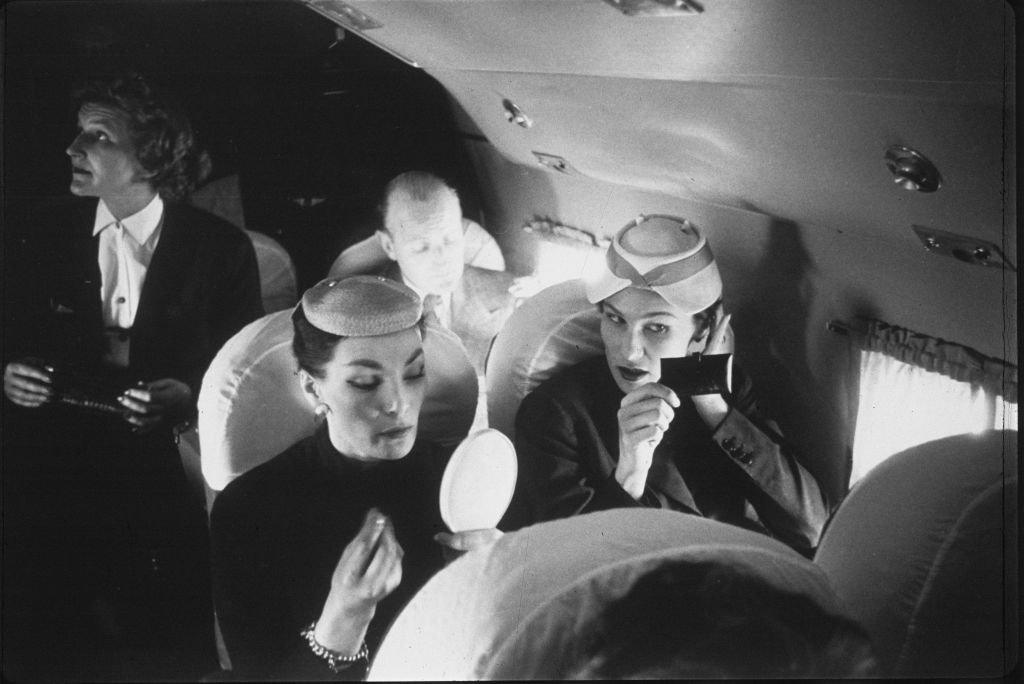 Two models apply their make-up during a flight to Scotland to take part in the Christian Dior fashion show. On the left is top model Lucie Daophars, known as Lucky.