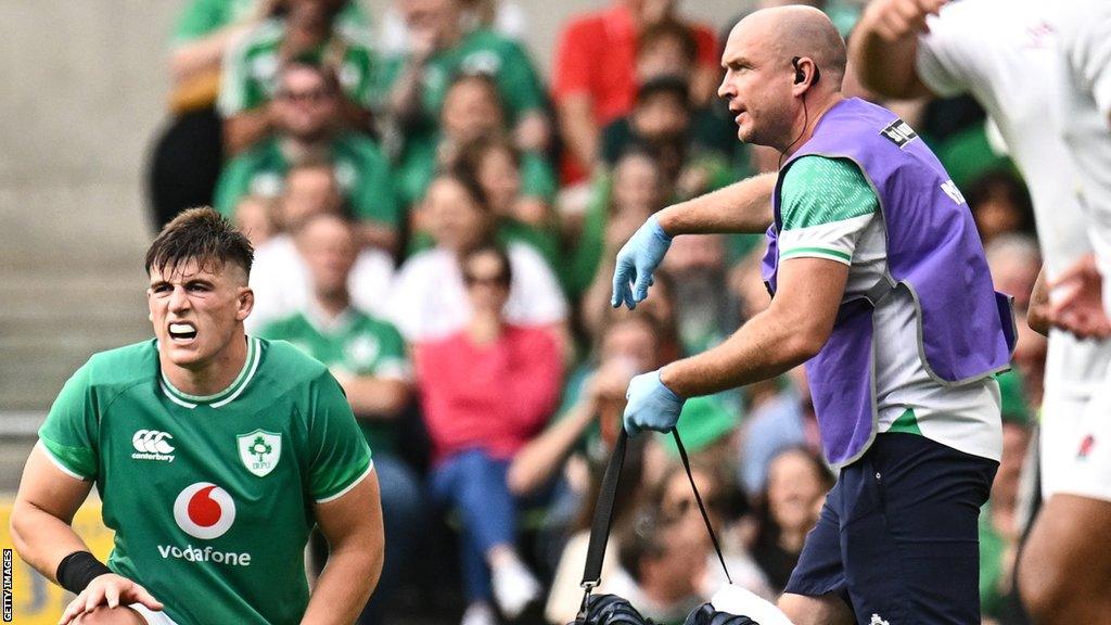 Dan Sheehan receives treatment after injuring his foot against England