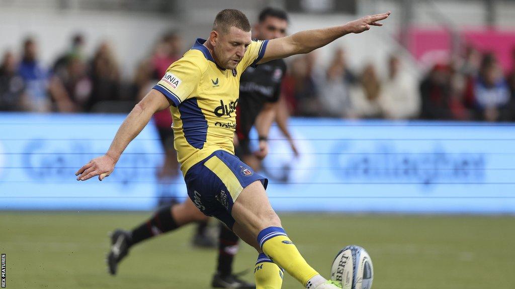 Finn Russell kicks the ball for Bath during their match with Leicester