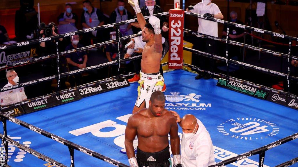 Daniel Dubois is escorted away by the referee as Joe Joyce celebrates