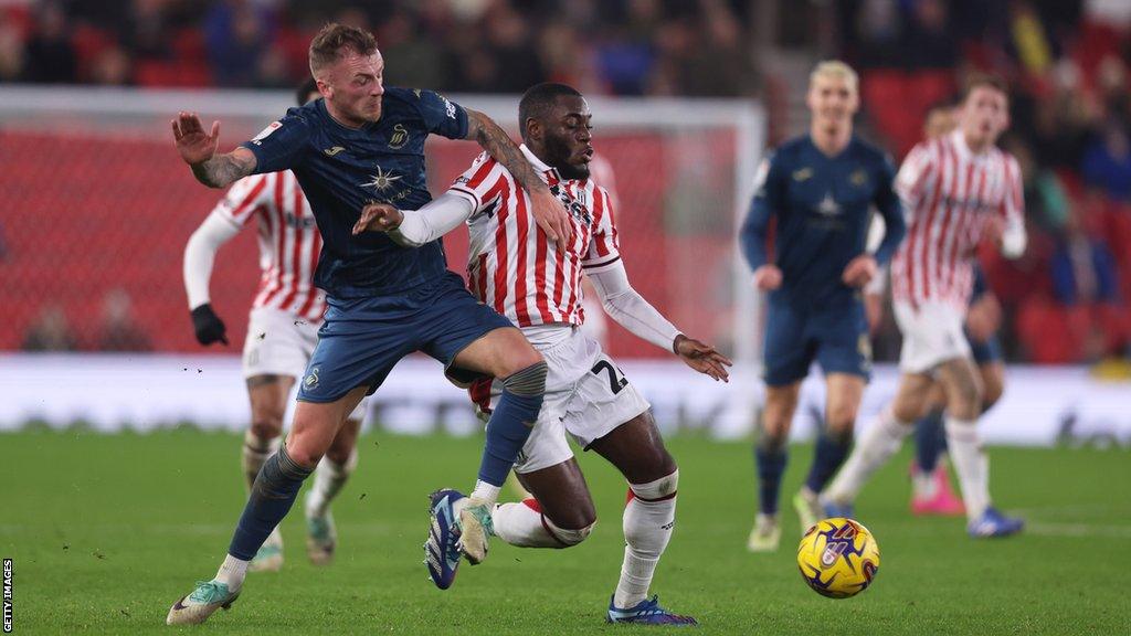 Junior Tchamadeu of Stoke City and Josh Tymon of Swansea compete for the ball