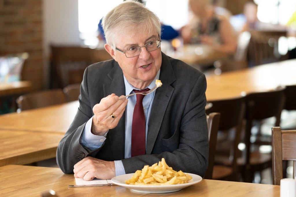 First Minister Mark Drakeford tucked into chips on a visit to a reopened restaurant in Cwmbran