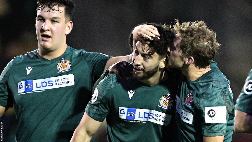 Ollie Hulbert (centre) celebrates with team mates after his winner against Caernarfon.