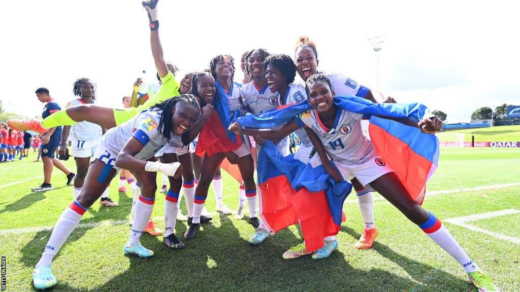 Haiti players pose for a photograph wrapped in their country's flag