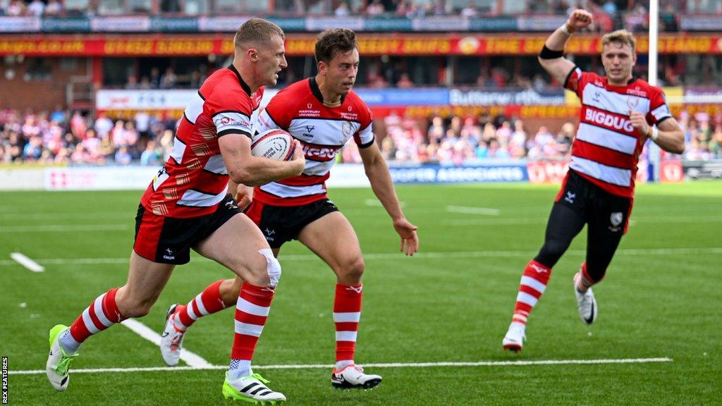 Gloucester's Alex Hearle (left) runs over with the ball to score a try as his team-mate celebrates (right)