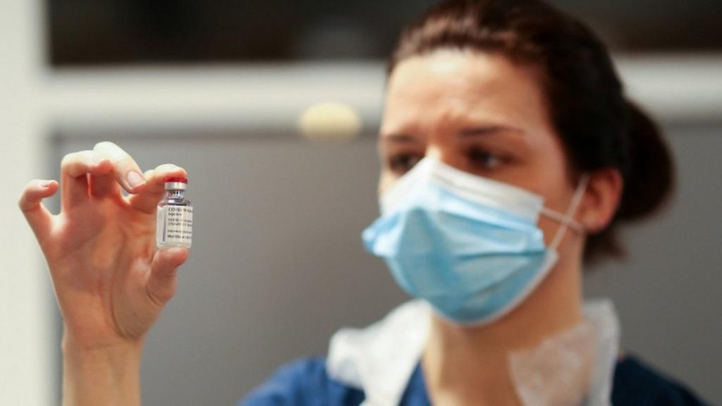 A health worker holds a Covid vaccine