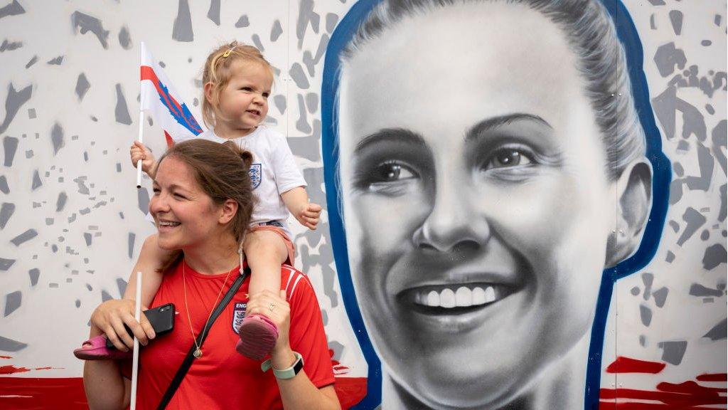 England fans celebrate in front of a muriel