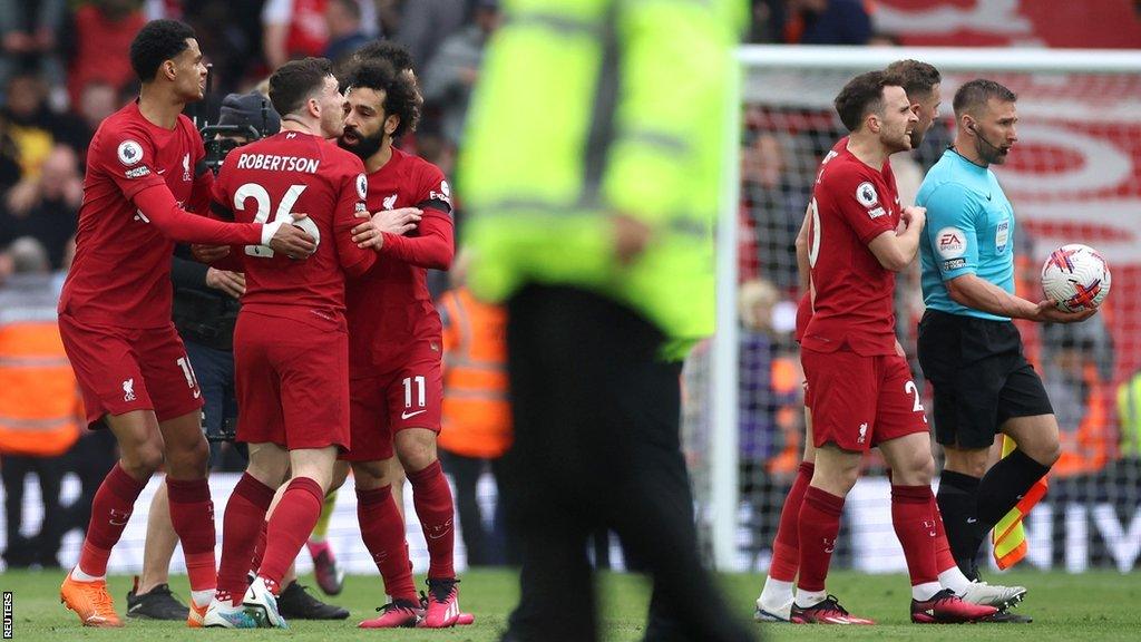 Andrew Robertson is held back by team-mates after a confrontation with the assistant referee