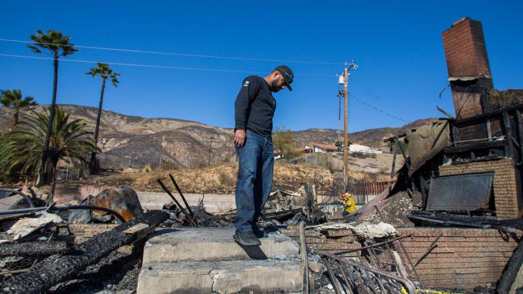 Matthew Valdivia looks for personal objects among the ashes of his home at Viento Way bear San Bernardino, California, on 31 October