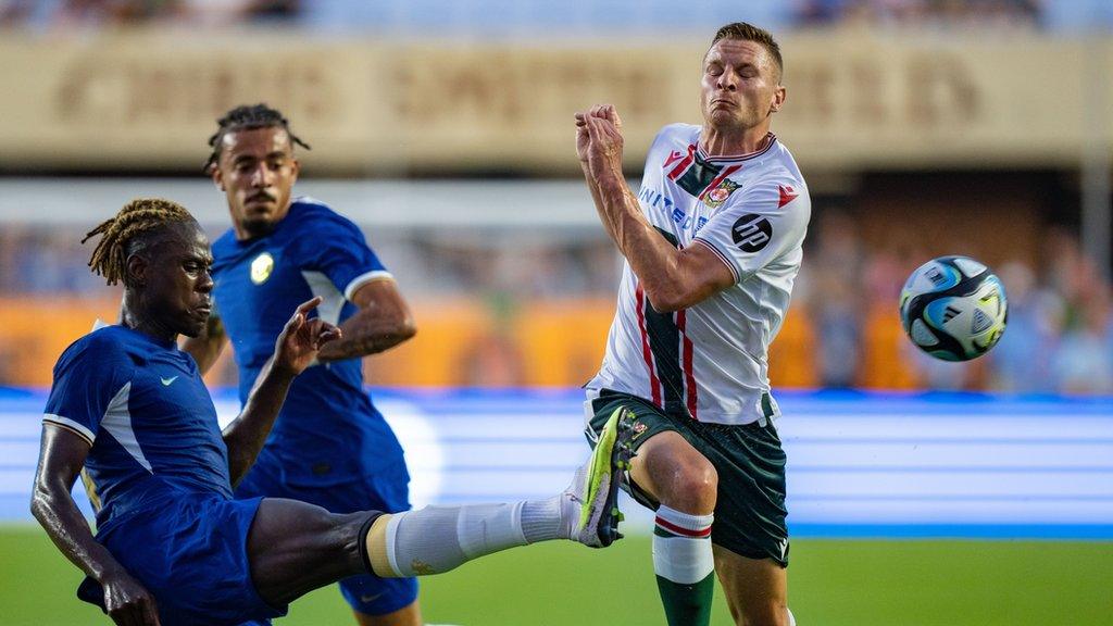 Trevoh Chalobah of Chelsea FC kicks the ball away from Paul Mullin of Wrexham