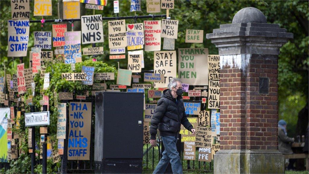 man-facemask-walks-signs-thank-you-nhs.