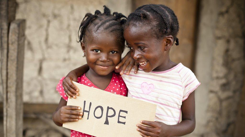 Girls holding a sign saying hope