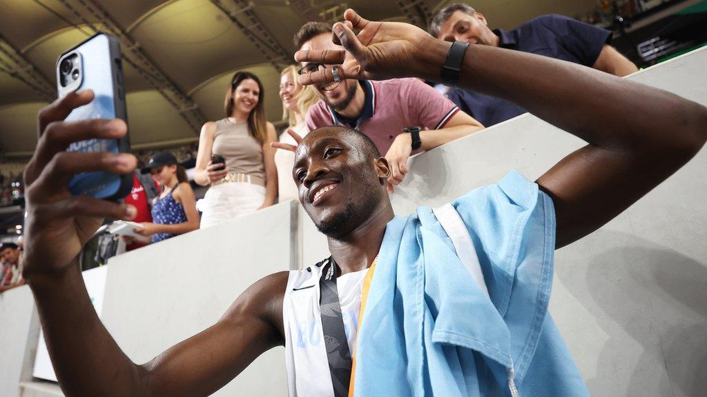 Letsile Tebogo of Botswana celebrates and takes photos with fans after winning bronze in the men's 200m final at the 2023 World Athletics Championships