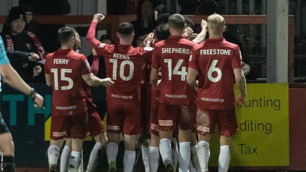 Cheltenham players celebrate a goal against Blackpool