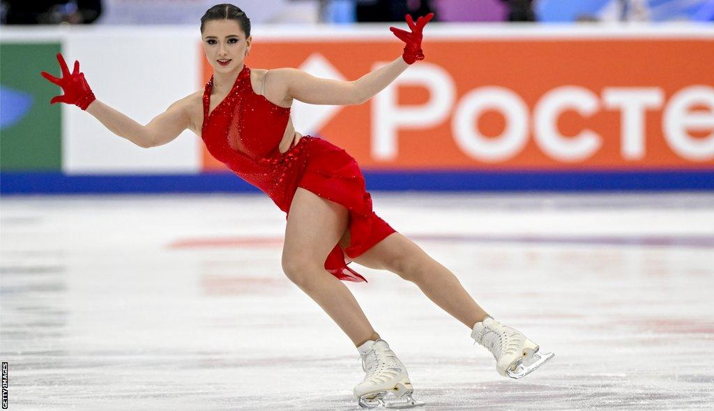 Kamila Valieva skating in a red outfit