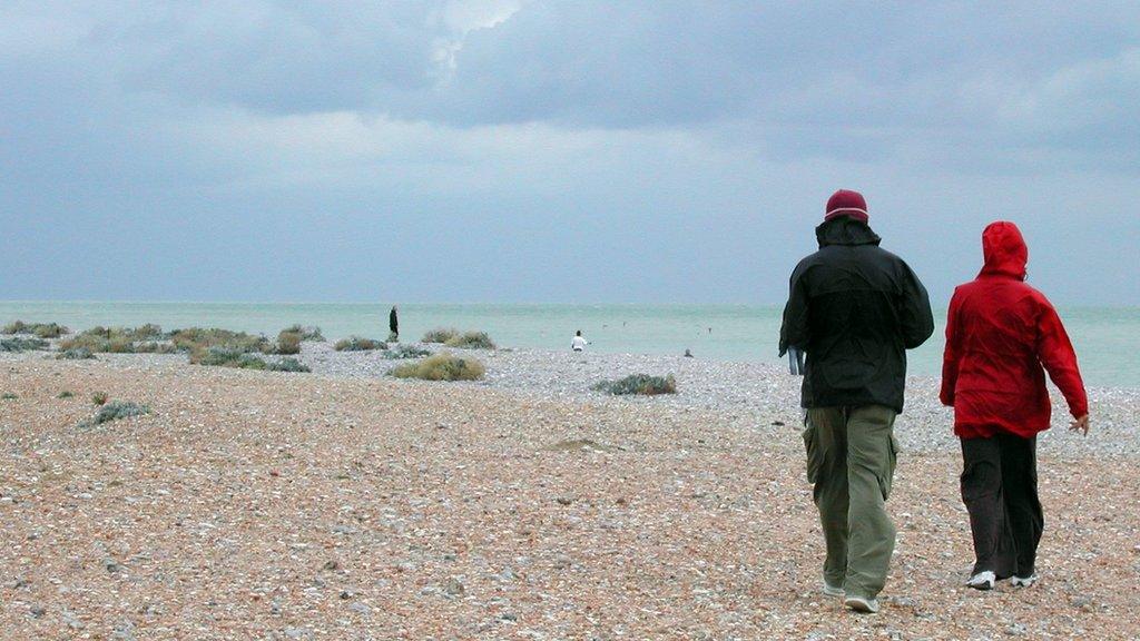 A couple stroll along the beach