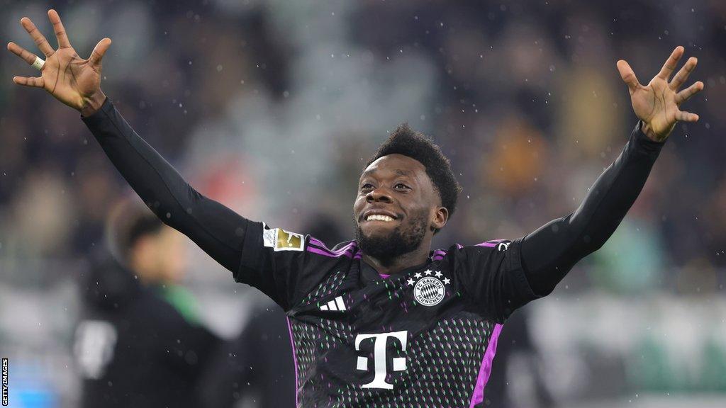 Bayern Munich's Alphonso Davies raising his arms during a match