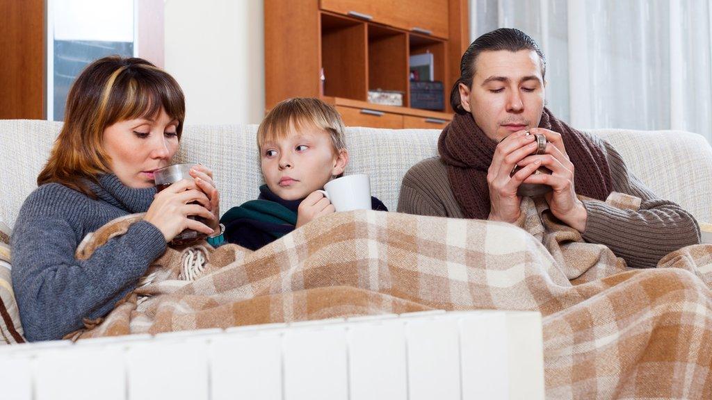 three people in a blanket on a sofa