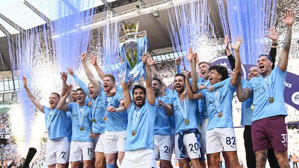 Manchester City players lift the Premier League trophy