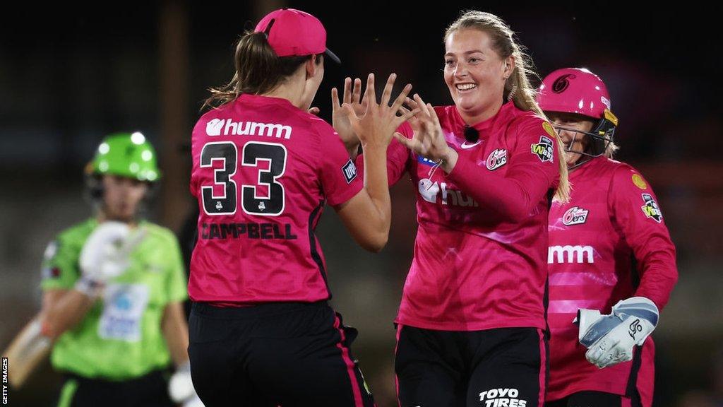 Sophie Ecclestone (left) celebrates a wicket for Sydney Sixers