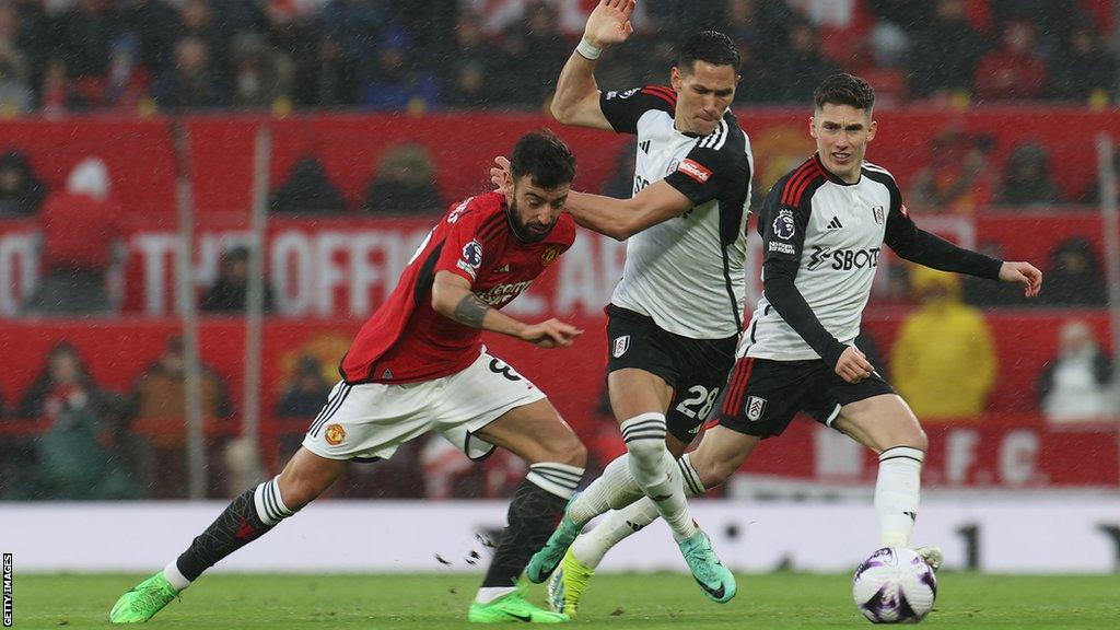 Bruno Fernandes of Manchester United in action with Sasa Lukic of Fulham