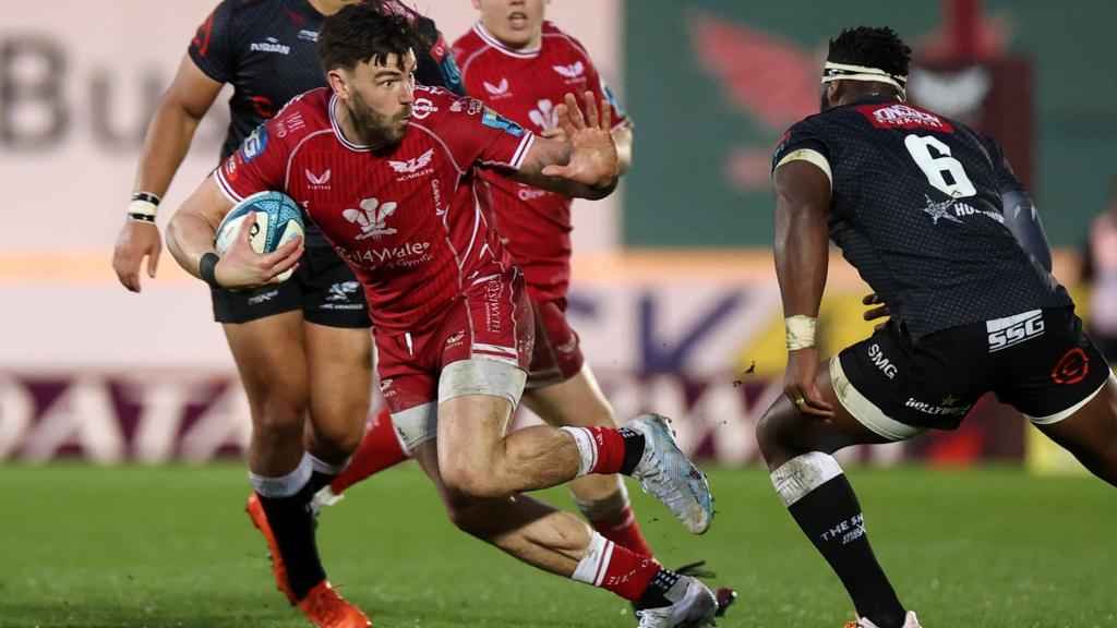 Johnny Williams of Scarlets is challenged by Siya Kolisi of Sharks