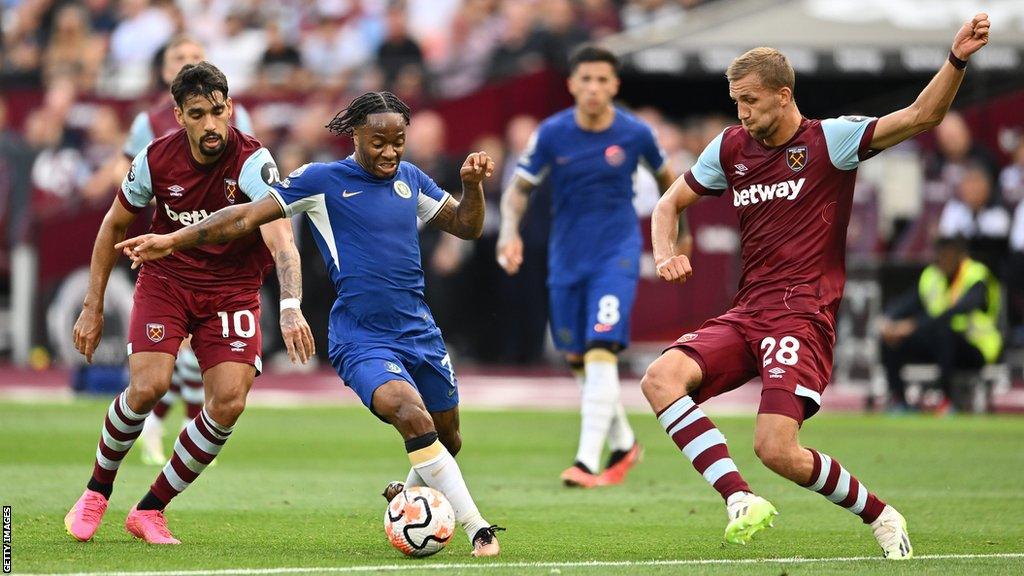 Raheem Sterling (centre) runs with the ball as Tomas Soucek (right) looks to tackle him