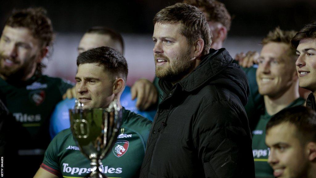 Ed Slater stands next to the Slater Cup with Leicester's players after their win in the fixture last December