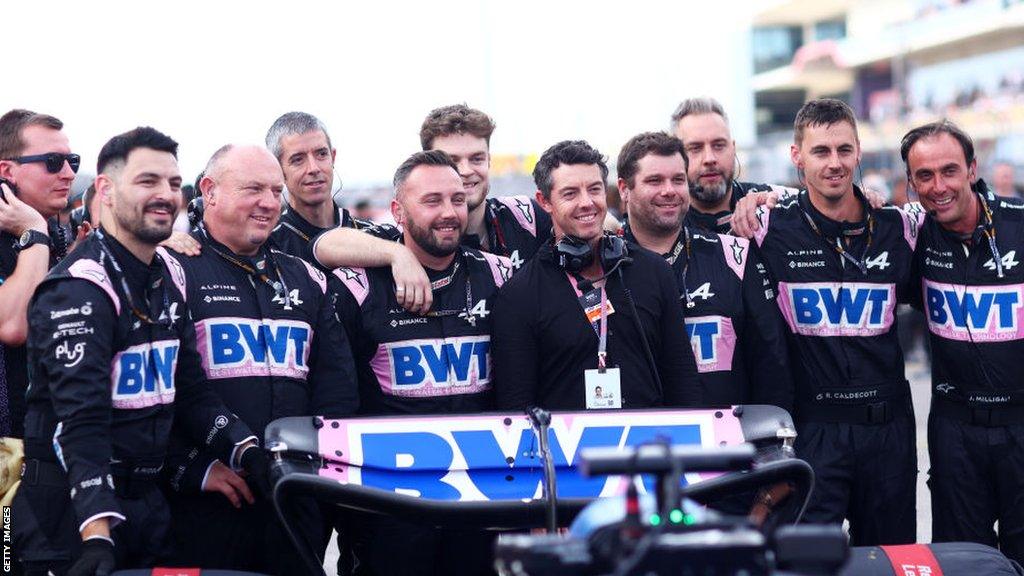 Rory McIlroy poses for a photo with Alpine F1 team members on the grid after recently becoming an investor in Otro Capital and Alpine F1