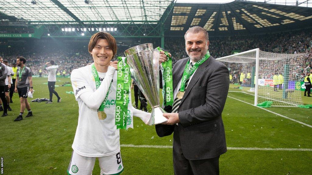 Kyogo Furuhashi and Ange Postecoglou hold the Premiership trophy