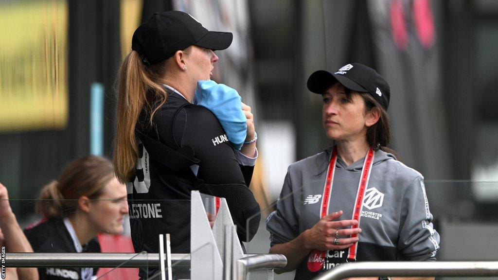 Sophie Ecclestone holding an ice pack on her injured shoulder