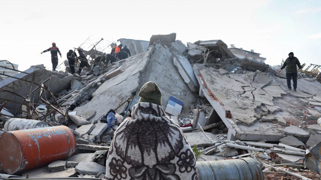 A man looks as rescuers and civilians search for survivors under the rubble of collapsed buildings in Kahramanmaras, close to the earthquake's epicentre, on February 8, 2023