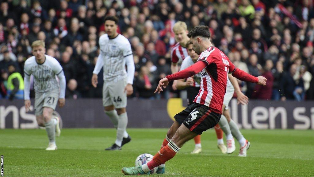 Lincoln City's Danny Mandroiu slips as he takes a penalty