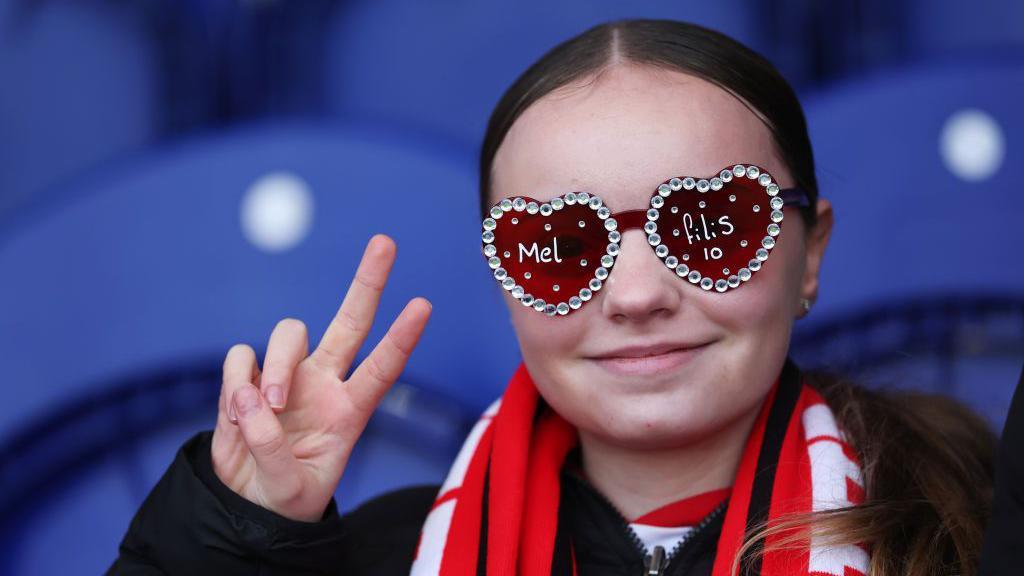 A young spectator poses for a photo prior to The Adobe Women's FA Cup Fourth Round match between Chelsea and Charlton Athletic at Kingsmeadow in Kingston upon Thames