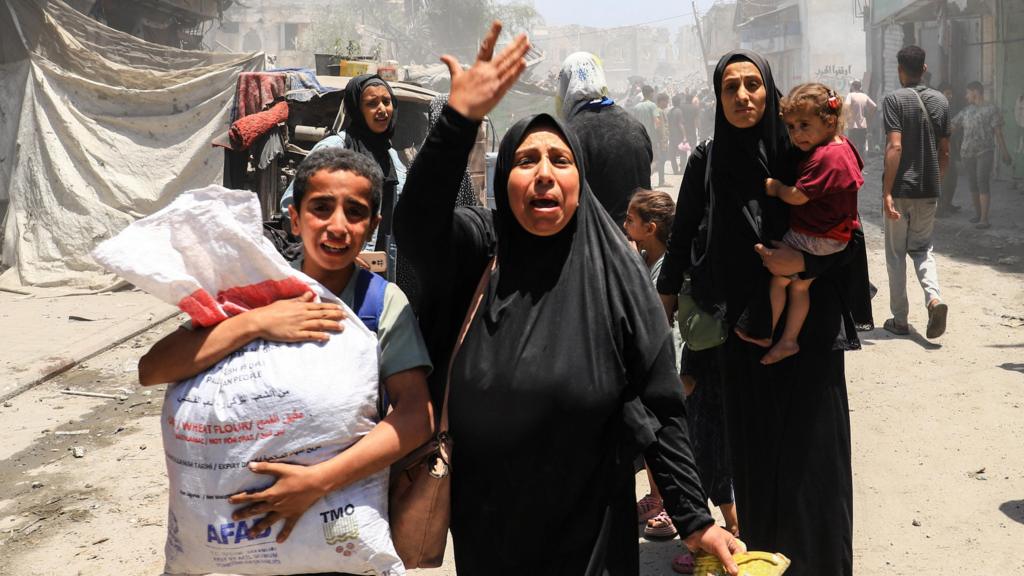 Palestinians evacuate in the aftermath of an Israeli strike on a house, in Gaza City