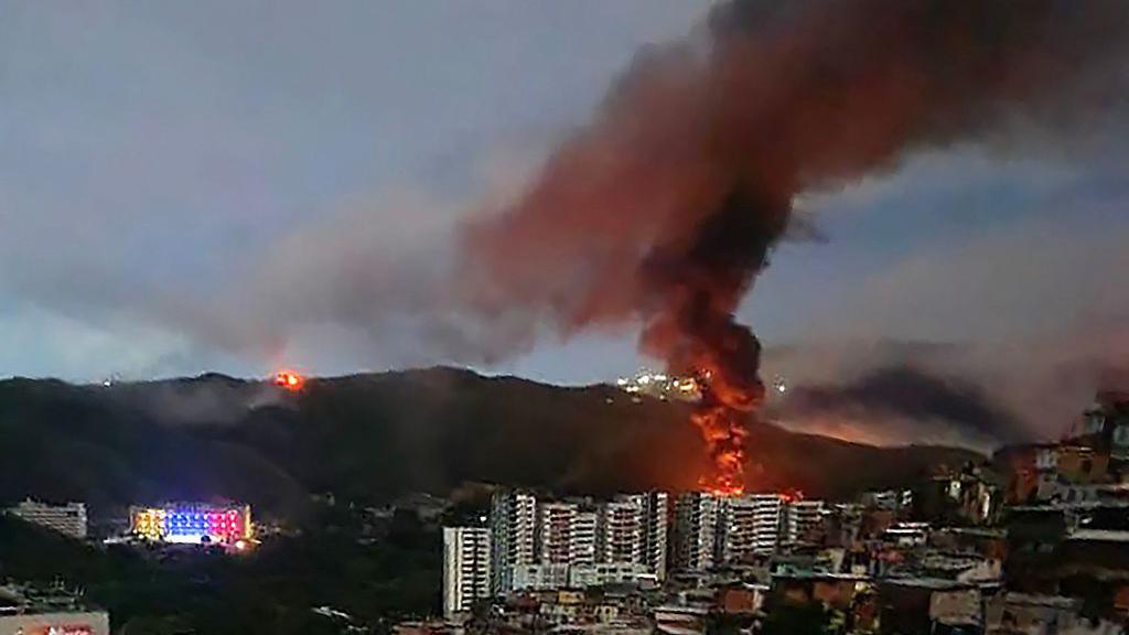 Fire at Fuerte Tiuna, Venezuela's largest military complex, is seen from a distance.