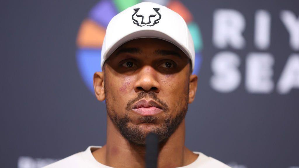 A bruised Anthony Joshua looks on at news conference